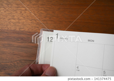 翻閱行程表的手,行程表從四月新年假期開始。 翻閱行程表的手,行程表從四月新年假期開始。 141374475