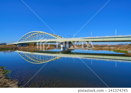 A view of the Tama Aqueduct Bridge reflected on the surface of the Tama River, from Higashi-Izumi, Komae City, Tokyo. A view of the Tama Aqueduct Bridge reflected on the surface of the Tama River, from Higashi-Izumi, Komae City, Tokyo. 141374745
