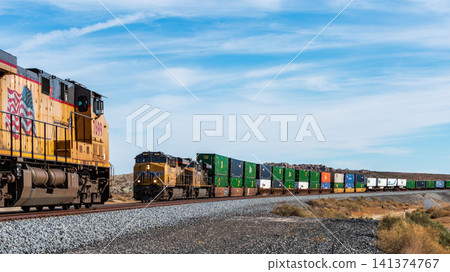 A Union Pacific Railroad container freight train powerfully traverses the American wilderness. A Union Pacific Railroad container freight train powerfully traverses the American wilderness. 141374767