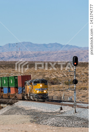 A Union Pacific Railroad container freight train powerfully traverses the American wilderness. 141374777