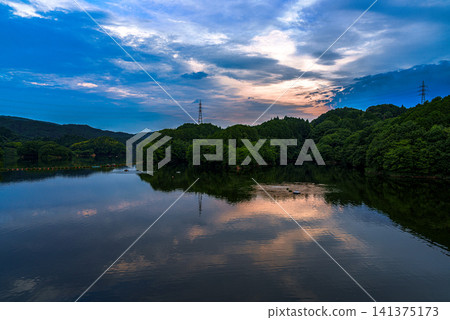 Sunset over Nunome Dam, a water source in Nara City: The golden sky over the mountains and its reflection on the lake surface (Part 2) Sunset over Nunome Dam, a water source in Nara City: The golden sky over the mountains and its reflection on the lake surface (Part 2) 141375173