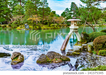 Kanazawa Kenrokuen Garden: Kasumigaike Pond with cherry blossom petals floating on it Kanazawa Kenrokuen Garden: Kasumigaike Pond with cherry blossom petals floating on it 141375345
