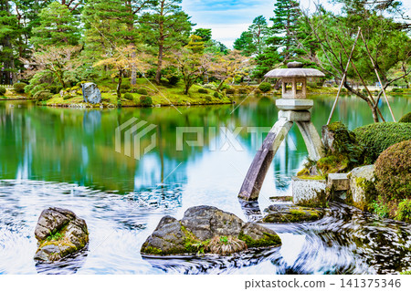 Kanazawa Kenrokuen Garden: Kasumigaike Pond with cherry blossom petals floating on it Kanazawa Kenrokuen Garden: Kasumigaike Pond with cherry blossom petals floating on it 141375346