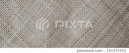 Hand-woven straw mat texture with a diagonal accent pattern. 141375355