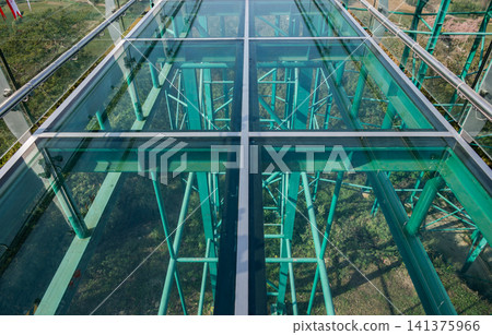 Below view of glass floor at skywalk in Wat Phrathat Pha Ngao temple for viewing Thailand and Laos border across Mekong river. Below view of glass floor at skywalk in Wat Phrathat Pha Ngao temple for viewing Thailand and Laos border across Mekong river. 141375966