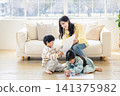 一位母親坐在沙發上，微笑著稱讚孩子們畫的畫。 141375982