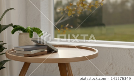Small wooden table with stack of books near window Small wooden table with stack of books near window 141376349