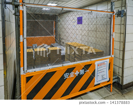 Storage status of tactile paving materials for station platform improvement work: Pre-construction materials piled up inside temporary enclosure. 141378883