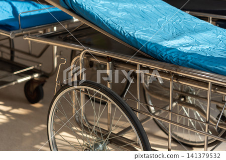 Empty hospital stretcher blue mattress prepared for patient transport medical facility highlighting emergency care healthcare safety clinical readiness Empty hospital stretcher blue mattress prepared for patient transport medical facility highlighting emergency care healthcare safety clinical readiness 141379532