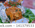 Steamed fish rich curry paste wrapped foil topped fresh herbs served crisp lettuce offering traditional flavorful seafood cuisine 141379533