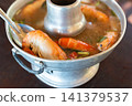 Traditional Thai shrimp tom yum hot pot served fresh herbs aromatic broth offering rich seafood flavors classic spicy meal 141379537