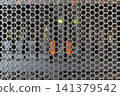 Close view of perforated metal mesh door computer server rack datacenter providing ventilation protection secure access for network equipment 141379542