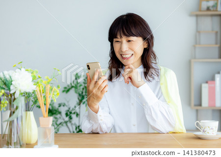 中老年女性正在看智慧型手機 中老年女性正在看智慧型手機 141380473