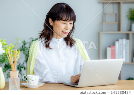 在客廳裡的中年女子遠程辦公 141380484