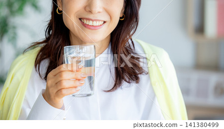 微笑的中年婦女在客廳喝藥 141380499