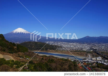 Mount Fuji and Mount Ashitaka stand out against a clear blue sky, with the Fujikawa River flowing by. January, Mount Fuji 2264, Tomei Expressway and Fujikawa River Mount Fuji and Mount Ashitaka stand out against a clear blue sky, with the Fujikawa River flowing by. January, Mount Fuji 2264, Tomei Expressway and Fujikawa River 141380878