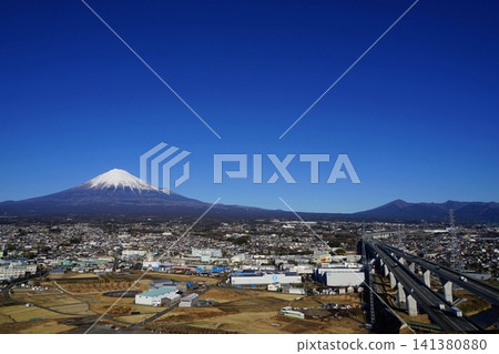 Mount Fuji and Mount Ashitaka stand out against a clear blue sky, with the Shin-Tomei Expressway running through the landscape. January, Mount Fuji 2268, Fujinomiya city and Shin-Tomei Expressway 141380880