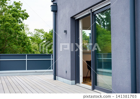 Open sliding glass door leads from rooftop terrace into modern apartment. Open sliding glass door leads from rooftop terrace into modern apartment. 141381703