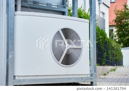 Heat pump unit mounted on steel frame near residential building Heat pump unit mounted on steel frame near residential building 141381704