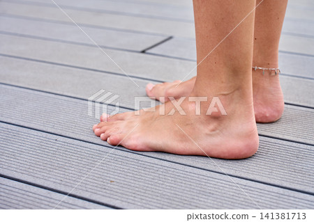 Barefoot Woman Standing on Outdoor Terrace Barefoot Woman Standing on Outdoor Terrace 141381713