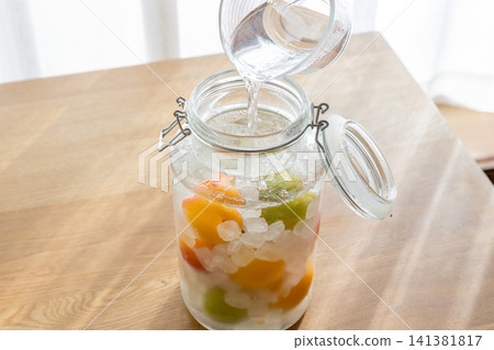 我正在將白酒倒入梅子酒的配料中。 我正在將白酒倒入梅子酒的配料中。 141381817