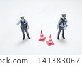 Miniature police officers stand near traffic safety cones. 141383067