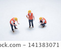 Miniature construction workers stand on plain white background. 141383071