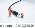 Miniature worker figures repairing a digital USB cable. 141383080