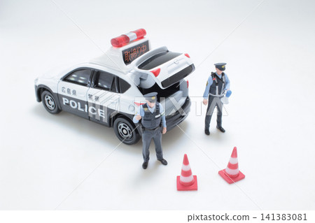 Miniature Japanese police officers stand by patrol car. Miniature Japanese police officers stand by patrol car. 141383081
