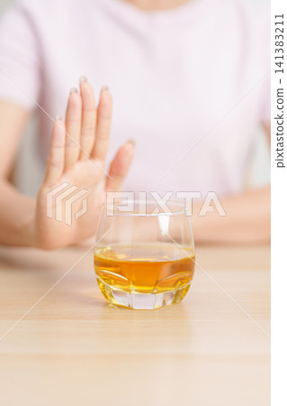 woman making stop hand gesture to refuse a glass of whiskey, Healthy man say no to alcohol drink, stop alcoholism and addiction concept. Responsible man reject a drink before driving and quit booze woman making stop hand gesture to refuse a glass of whiskey, Healthy man say no to alcohol drink, stop alcoholism and addiction concept. Responsible man reject a drink before driving and quit booze 141383211
