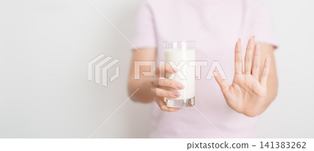Lactose intolerance and Milk allergy. woman hand stop and refuse Milk, having abdominal cramps and pain when drink Cow Milk. Symptom stomach ache, Dairy intolerant, Nausea, Bloating, Gas and Diarrhea 141383262