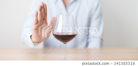 man making stop hand gesture to refuse a glass of Wine, Healthy man say no to alcohol drink, stop alcoholism and addiction concept. Responsible man reject a drink before driving and quit booze man making stop hand gesture to refuse a glass of Wine, Healthy man say no to alcohol drink, stop alcoholism and addiction concept. Responsible man reject a drink before driving and quit booze 141383318