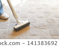 The hands cleaning the carpet with a vacuum cleaner 141383692