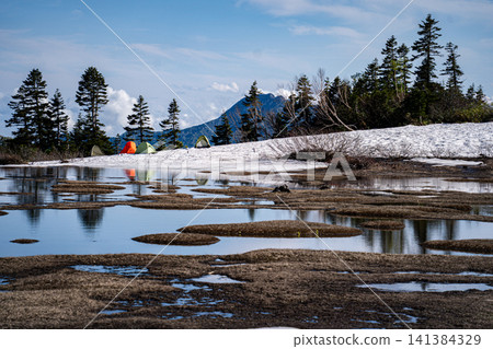 Mount Hiuchi in early summer and the plateau covered in melting snow. Mount Hiuchi in early summer and the plateau covered in melting snow. 141384329
