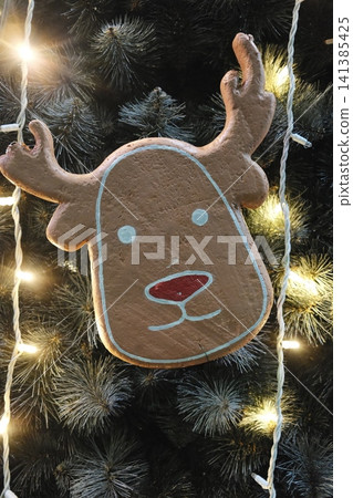 Iced reindeer with red nose on a glowing Christmas tree at night. 141385425
