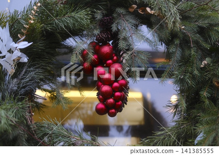 Evergreen wreath decorates front door for Christmas Evergreen wreath decorates front door for Christmas 141385555