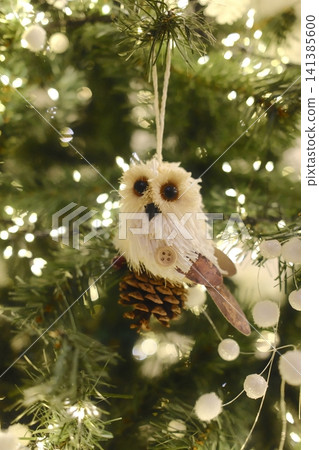 Handmade owl ornament on a festive Christmas tree Handmade owl ornament on a festive Christmas tree 141385600
