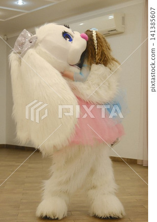 White furry mascot embraces young girl at celebration White furry mascot embraces young girl at celebration 141385607