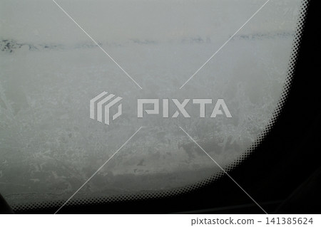 Frost covered car windshield on a cold winter day Frost covered car windshield on a cold winter day 141385624
