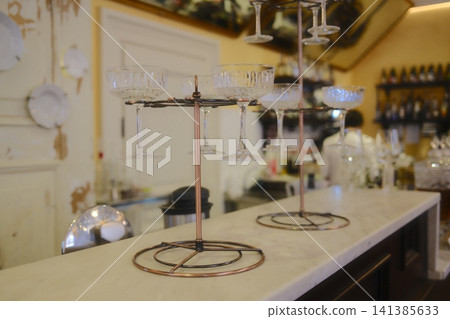 Coupe glasses displayed on stands at a restaurant bar Coupe glasses displayed on stands at a restaurant bar 141385633