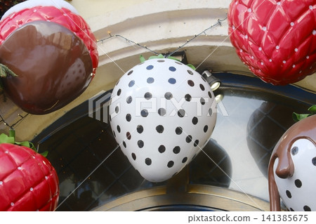 Close-up of giant decorative artificial strawberry props on building facade Close-up of giant decorative artificial strawberry props on building facade 141385675