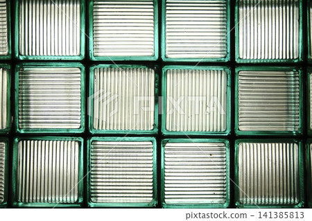 A wall of square glass blocks features alternating horizontal and vertical ribbed patterns A wall of square glass blocks features alternating horizontal and vertical ribbed patterns 141385813