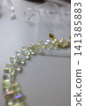 A shimmering necklace of light-colored, teardrop-shaped iridescent beads 141385883