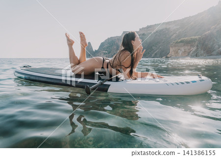 Woman Paddleboard Ocean Relaxing on Paddleboard in Ocean Woman Paddleboard Ocean Relaxing on Paddleboard in Ocean 141386155