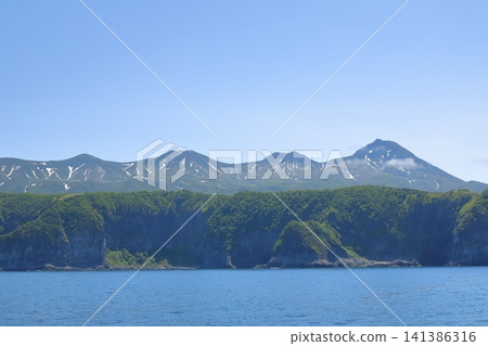 A refreshing view of the Shiretoko mountain range in early summer, with lingering snow. A refreshing view of the Shiretoko mountain range in early summer, with lingering snow. 141386316