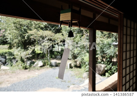 夏日微風拂過老農舍的陽台,傳統的風鈴靜靜地響著。 夏日微風拂過老農舍的陽台,傳統的風鈴靜靜地響著。 141386587