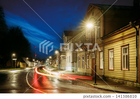 Illuminated historic wooden buildings and car light trails on Kuressaare street at winter night Illuminated historic wooden buildings and car light trails on Kuressaare street at winter night 141386810