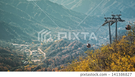 Aerial View of Cable Cars Over Autumnal Mountain Range Aerial View of Cable Cars Over Autumnal Mountain Range 141386827