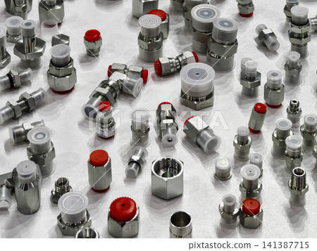 Various metal fittings and connectors spread on a table in a workshop Various metal fittings and connectors spread on a table in a workshop 141387715
