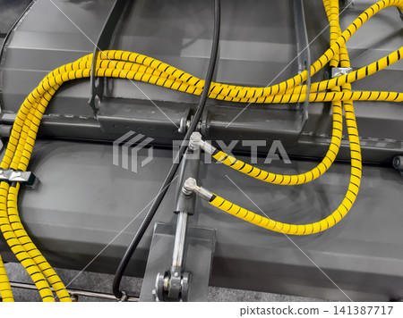 Detail of machinery with yellow cables and connections in a factory setting Detail of machinery with yellow cables and connections in a factory setting 141387717